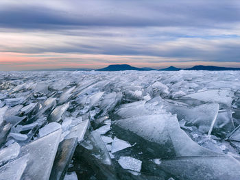 Scenic view of snow covered landscape against sky during sunset