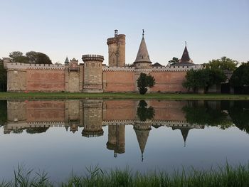 Reflection of building in lake against clear sky