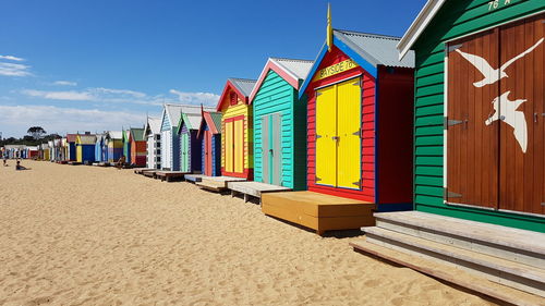 Beach huts by buildings against sky