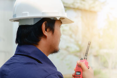 Engineer holding walkie-talkie at construction site