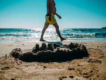 Full length of woman on beach against clear sky