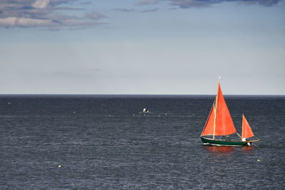 Sailboat in sea against sky