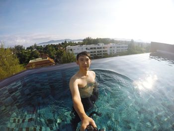 Man swimming in pool against sky