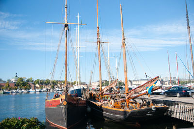 Sailboats moored at harbor