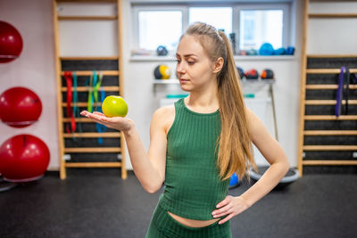 Portrait of young woman exercising in gym