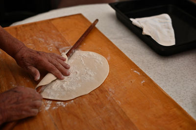 Person preparing dough on cutting board