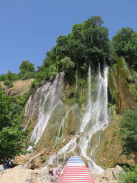 Scenic view of waterfall in forest against sky