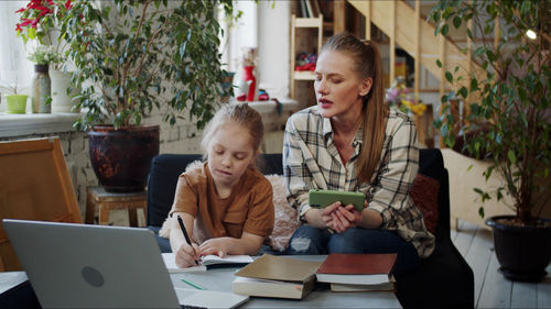 Mother teaching daughter at home