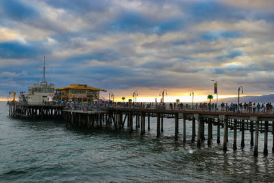 Pier over sea against sky during sunset