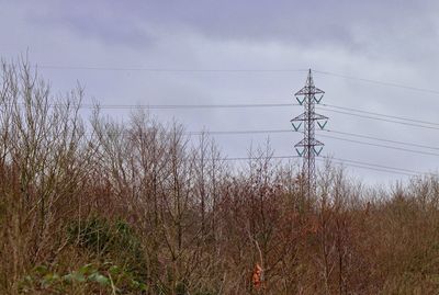 Low angle view of electricity pylon against sky