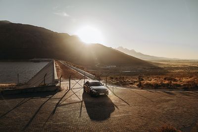 Car on road against sky during sunset