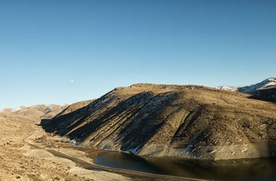 Scenic view of desert against clear blue sky