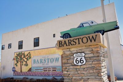 Low angle view of text on building against clear blue sky