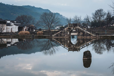 Arch bridge over lake against sky