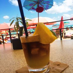 Close-up of water on table at beach against sky