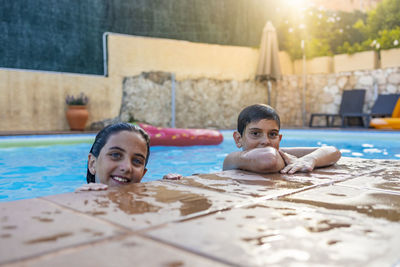 Portrait of two kids on a pool side