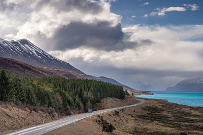 Mount cook road alongside lake pukaki with snow capped southern alps in winter evening light. 