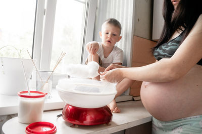 Midsection of mother and daughter in window