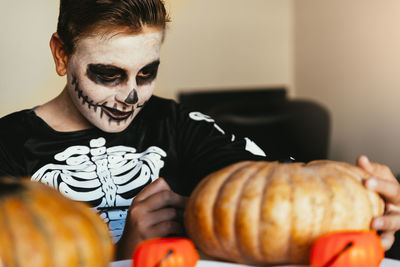 Midsection of man with pumpkin in halloween