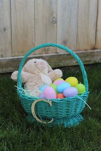 Close-up of easter eggs and bunny in wicker basket at yard