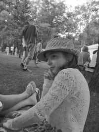 Thoughtful girl sitting on field at park