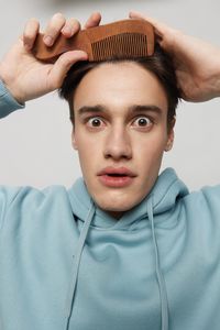 Portrait of young man standing against white background