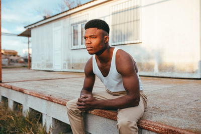 Full length of young man sitting outdoors