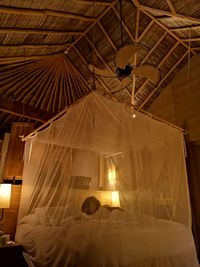 Woman lying in four poster bed at hotel