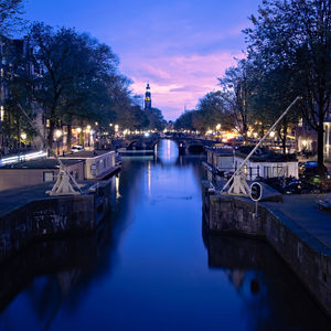 Bridge over canal against sky at dusk