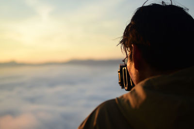 Portrait of man using mobile phone against sky