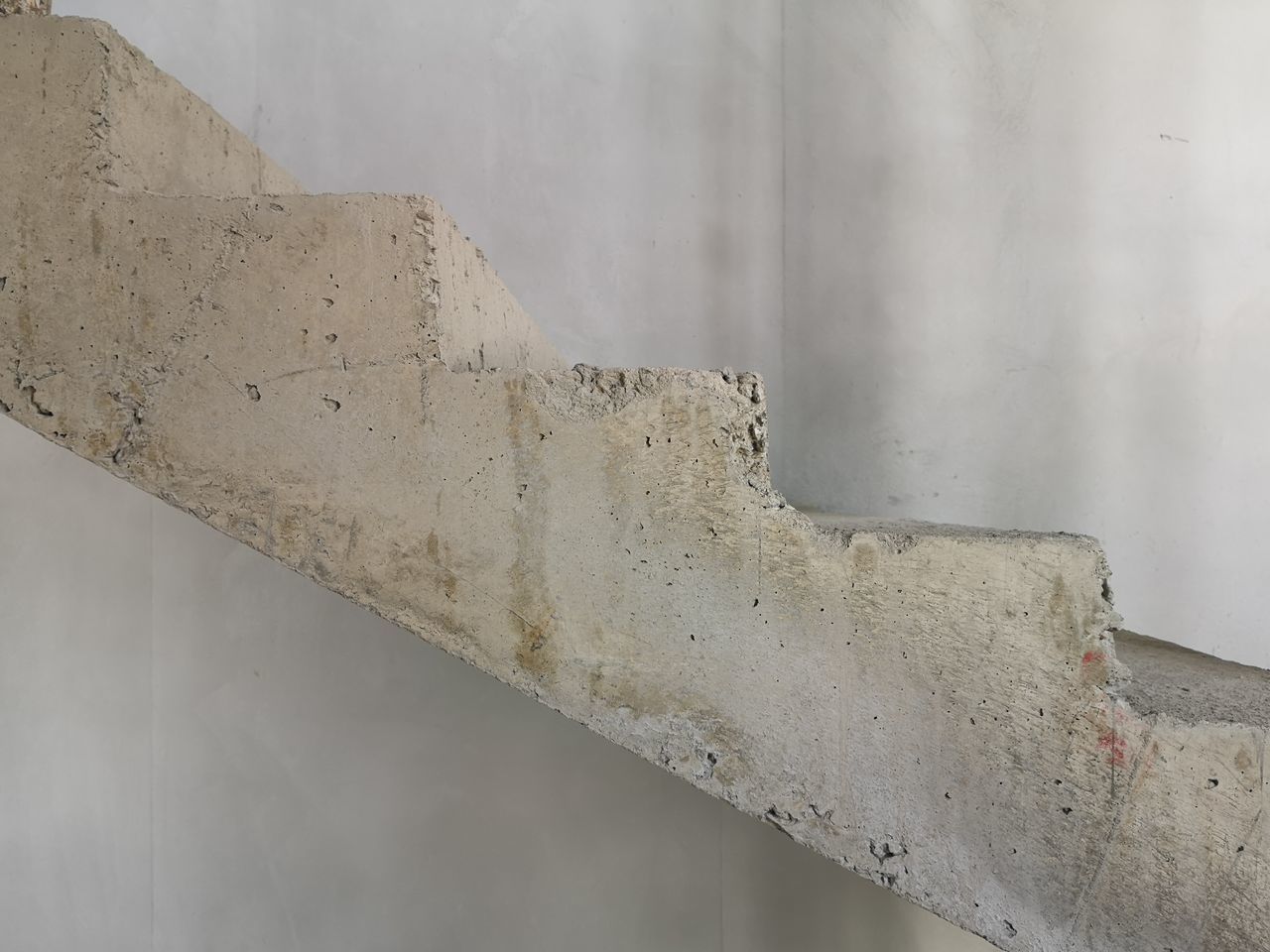 CLOSE-UP OF WHITE WALL WITH METAL PIPE