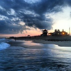 Scenic view of sea against cloudy sky during sunset