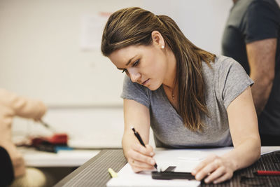 Female engineering planning on paper with colleagues in background