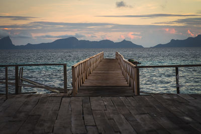 Pier over sea against sky during sunset