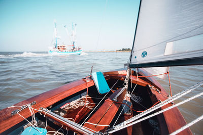 Sailboats moored in sea against clear sky