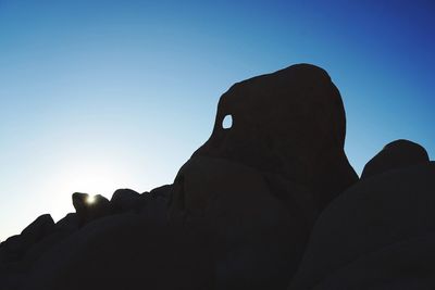 Close-up of silhouette man against sky