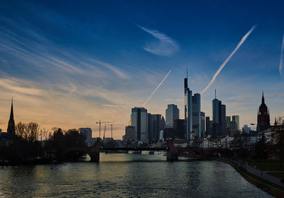 Bridge over river main with city buildings in background