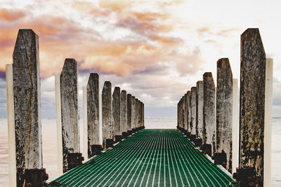 Pier against cloudy sky during sunset