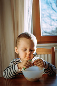 Portrait of cute baby boy sitting on the table at home