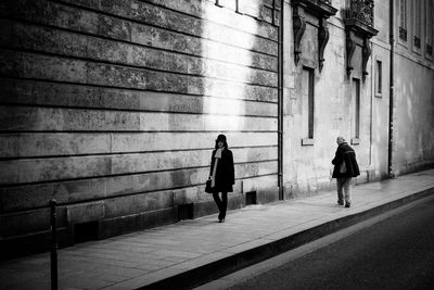 Silhouette people walking on road in city