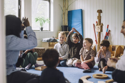 Female child care worker teaching boys and girls in day care center