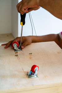 Close-up of person working with castor wheel on table