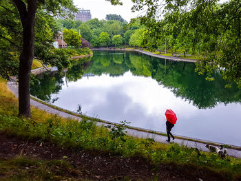 Reflection of woman on lake against sky