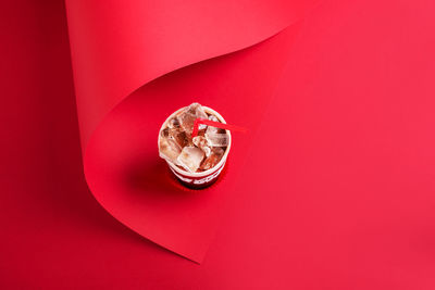 High angle view of red umbrella against pink background