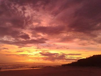 Scenic view of sea against dramatic sky during sunset