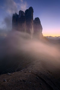 Tre cime di lavaredo in the italian dolomites with full moon and a sky full of stars.