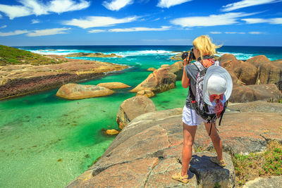 Rear view of woman looking at sea shore against sky