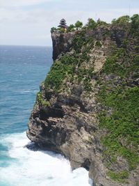 Rock formations by sea against sky