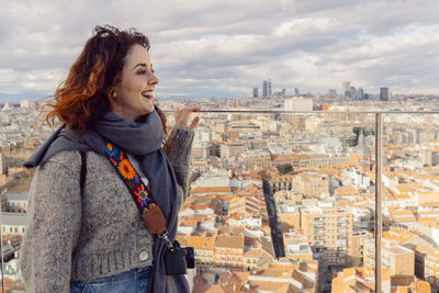 Smiling woman standing against cityscape