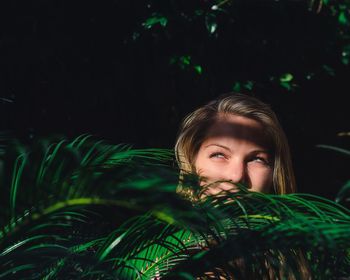 Close-up portrait of smiling young woman against tree